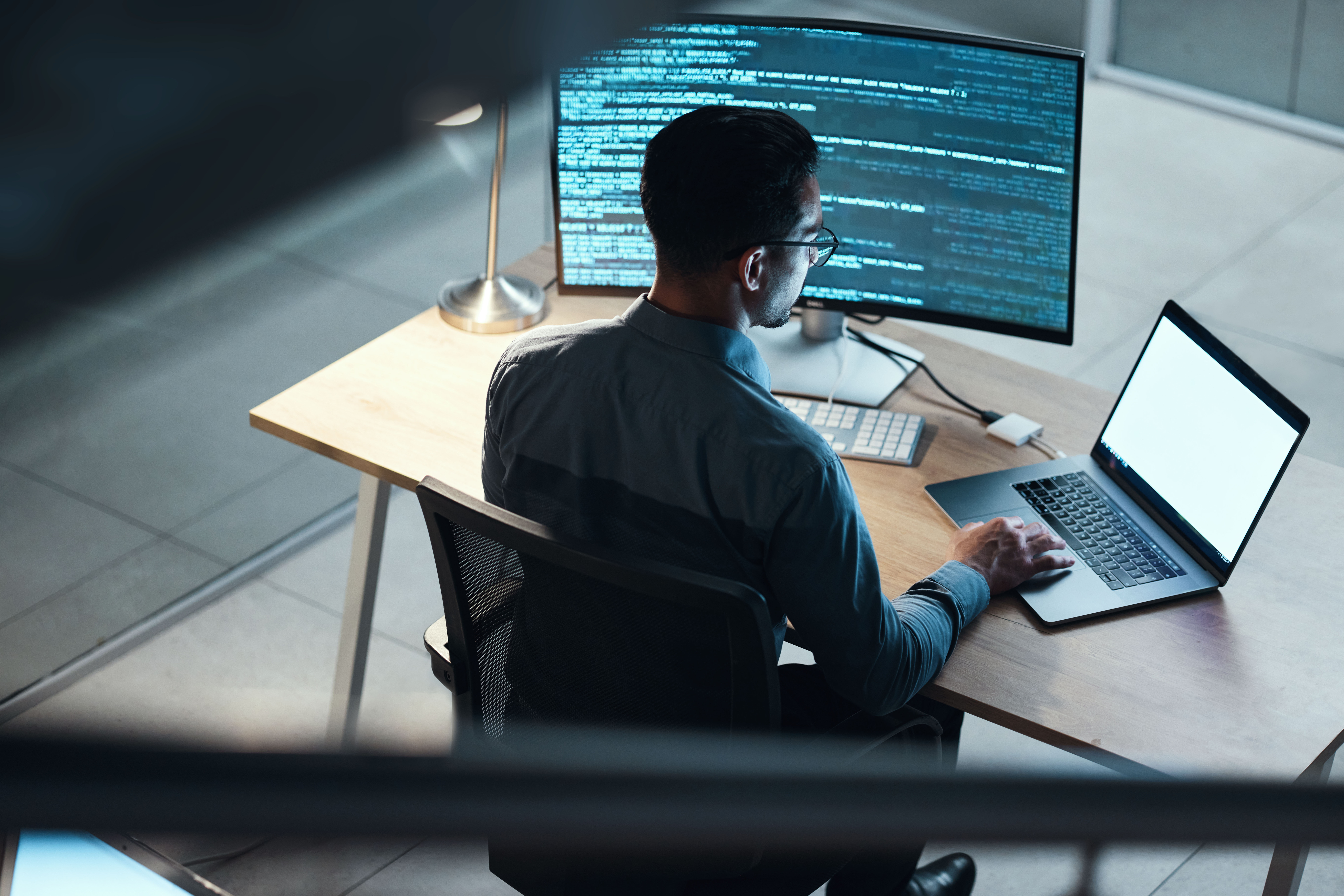 Software developer reviewing code at a workstation.